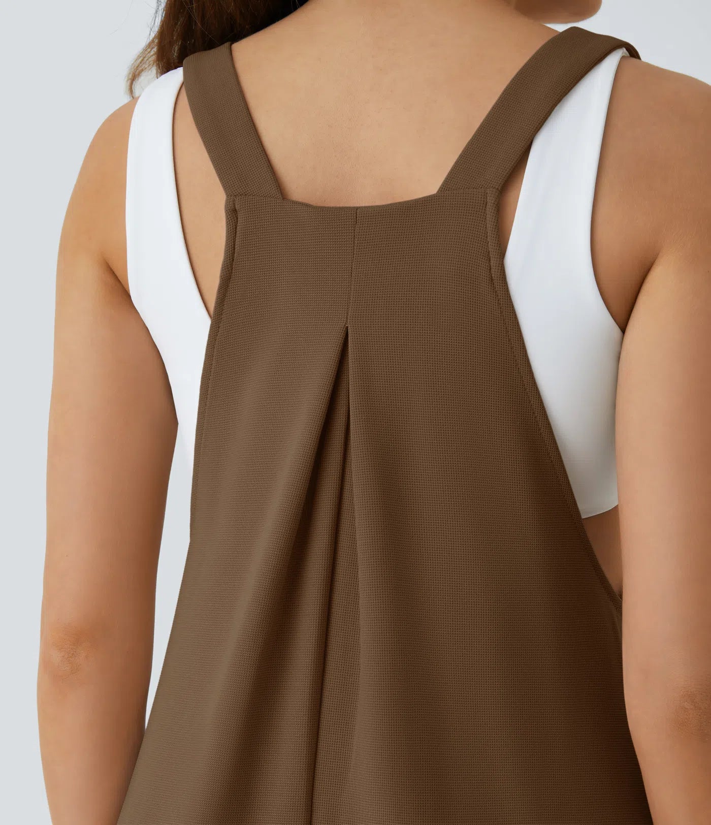 Jogger jumpsuit with adjustable belt and buttons, multiple pockets, and waffle pattern
